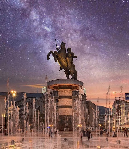 sküp Makedonya Meydanı'nda Büyük İskender Heykeli ve neoklasik mimariyle çevrili modern çeşmeler.