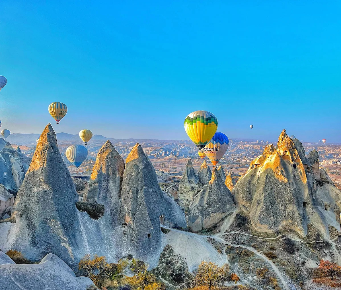 Kapadokya’da kış manzarasında yükselen sıcak hava balonları ve peribacaları panoraması